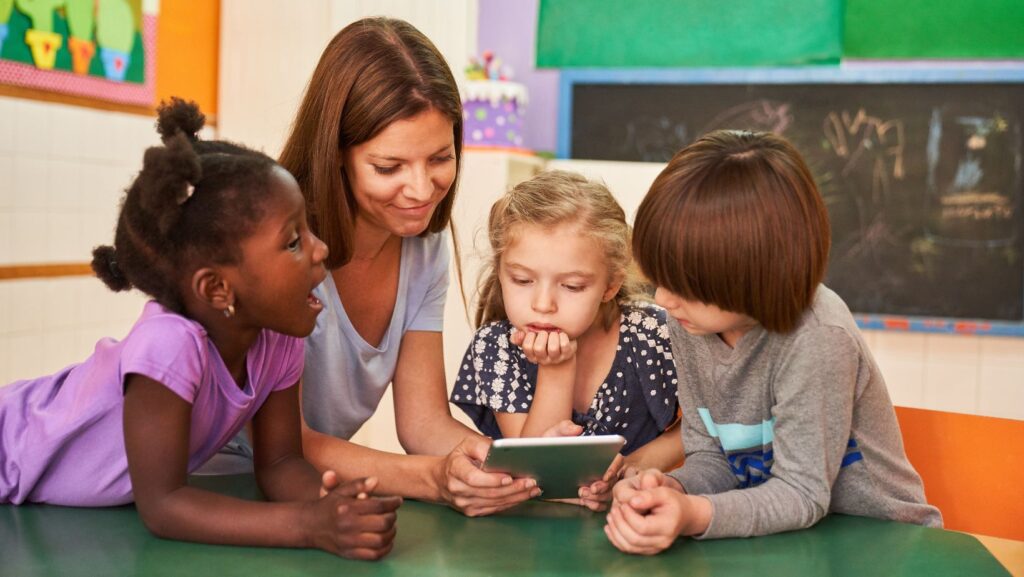 educatrice che mostra qualcosa ai bambini sul tablet